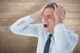 Stressed businessman with hands on head against wooden surface with planks
