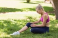 Full length of a healthy and beautiful young woman in sportswear sitting in the park