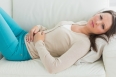 Anxious and sick woman lying on sofa in the living room