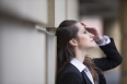 Businesswoman banging her head against a wall.