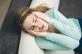 young woman with headache holding hands on head