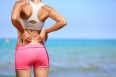 Back pain - Athletic woman rubbing her back